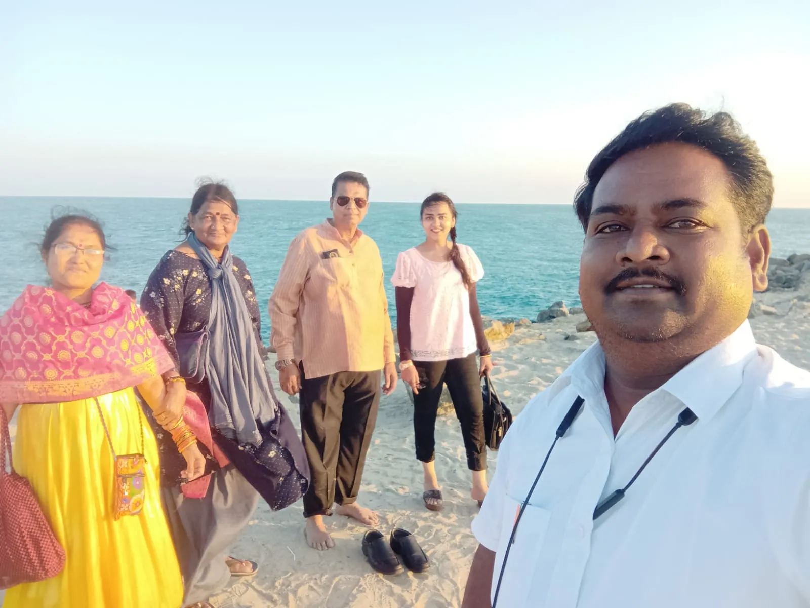 Sri Meenakshi Travels driver with a happy family on a seaside trip